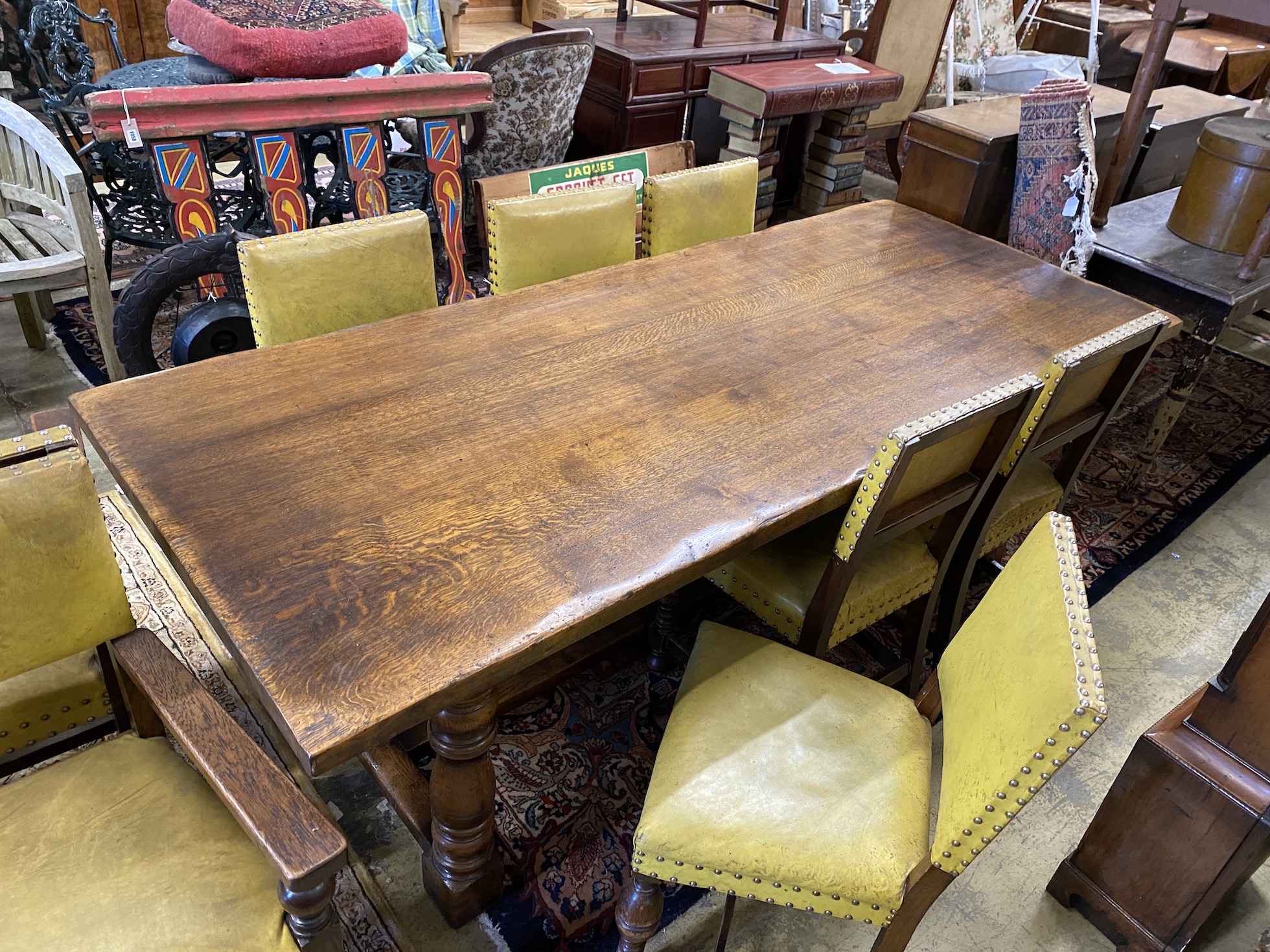 An 18th century style rectangular oak refectory dining table, length 224cm, width 92cm, height 77cm and eight dining chairs (2 with arms)